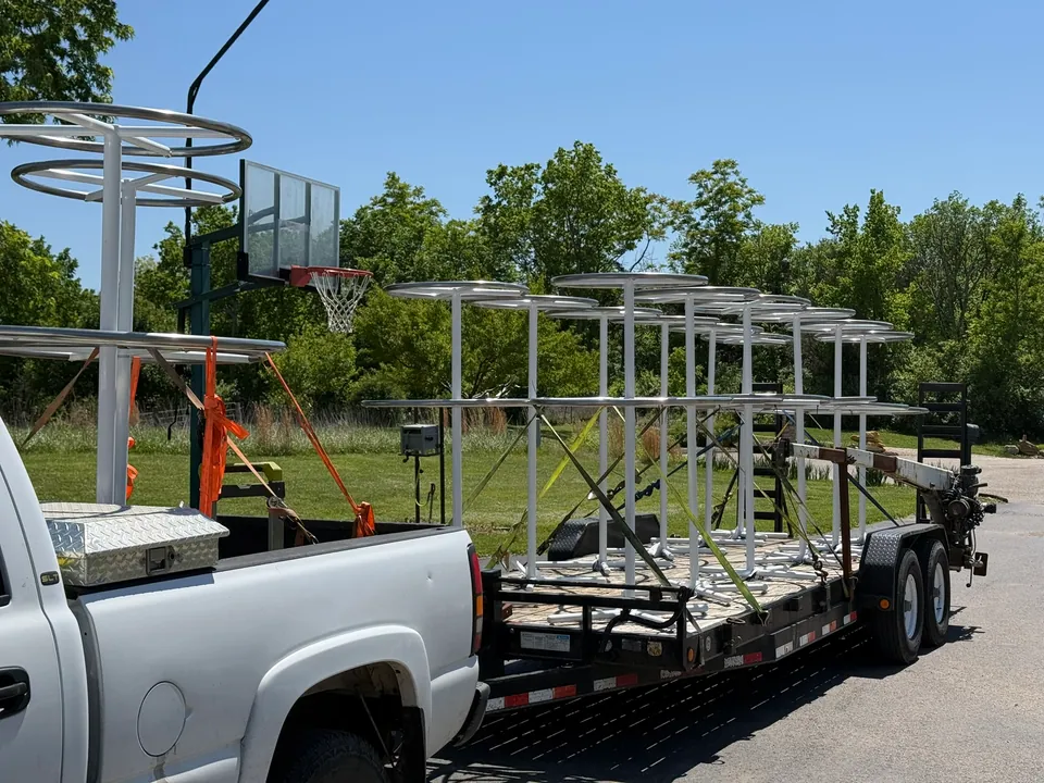 Multiple white fabricated fabric-display fixtures secured on a trailer for transport
