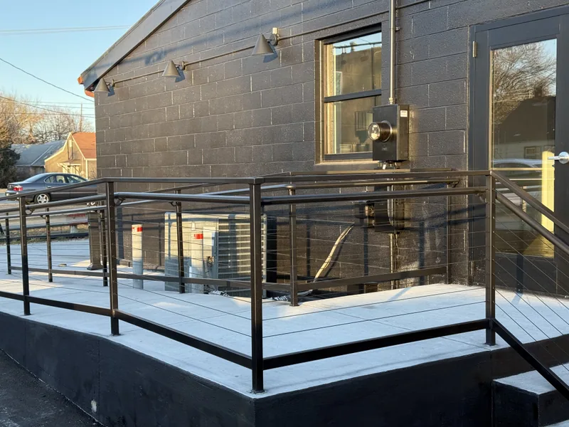 Custom metal railings installed around an exterior landing and ramp