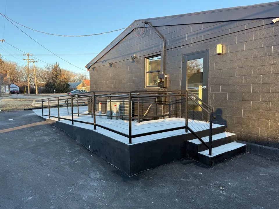 Completed black steel railings around an exterior landing and ramp