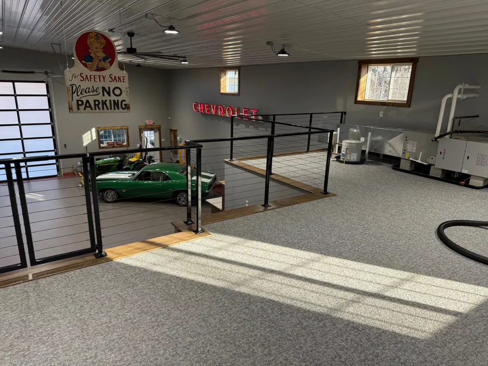 Wide view of completed black cable railing around an upper-level loft