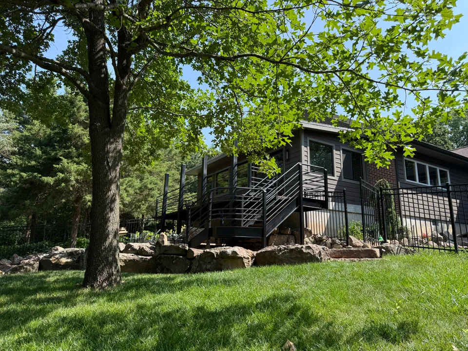 Completed exterior steel staircase and railings installed beside a home