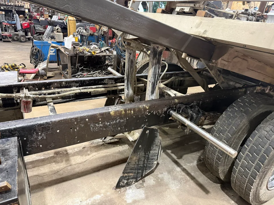 Tandem-axle trailer positioned in the shop for structural repair work